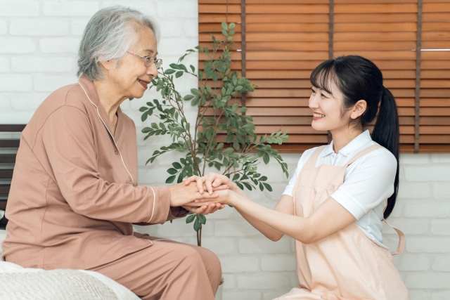 ご利用者さんの手をとって寄り添う看護師